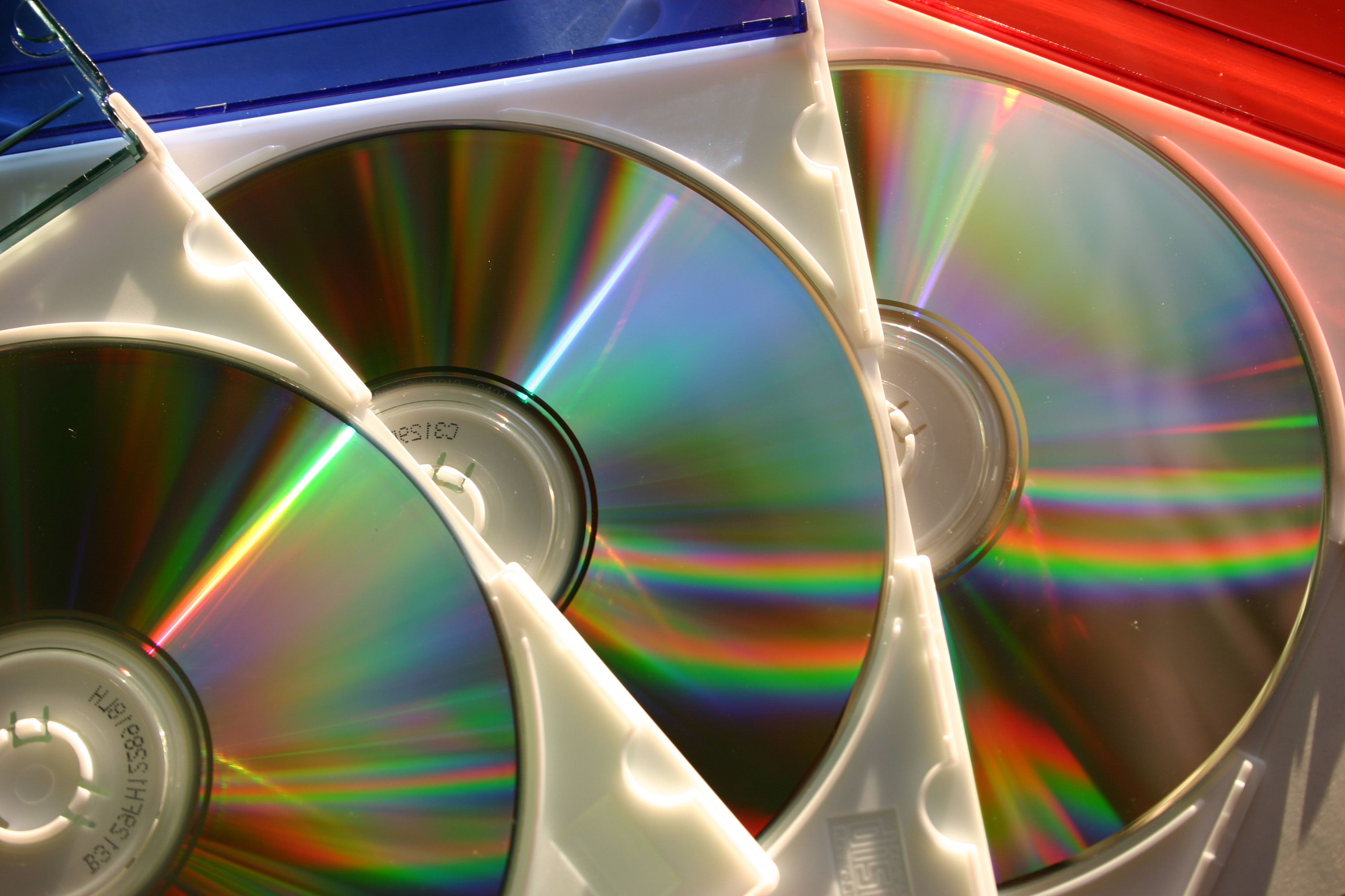 Много использованных дисков. Лазерный диск. Голограмма на диске. Перезаписываемый лазерный компакт-диск. Лазерная запись информации.