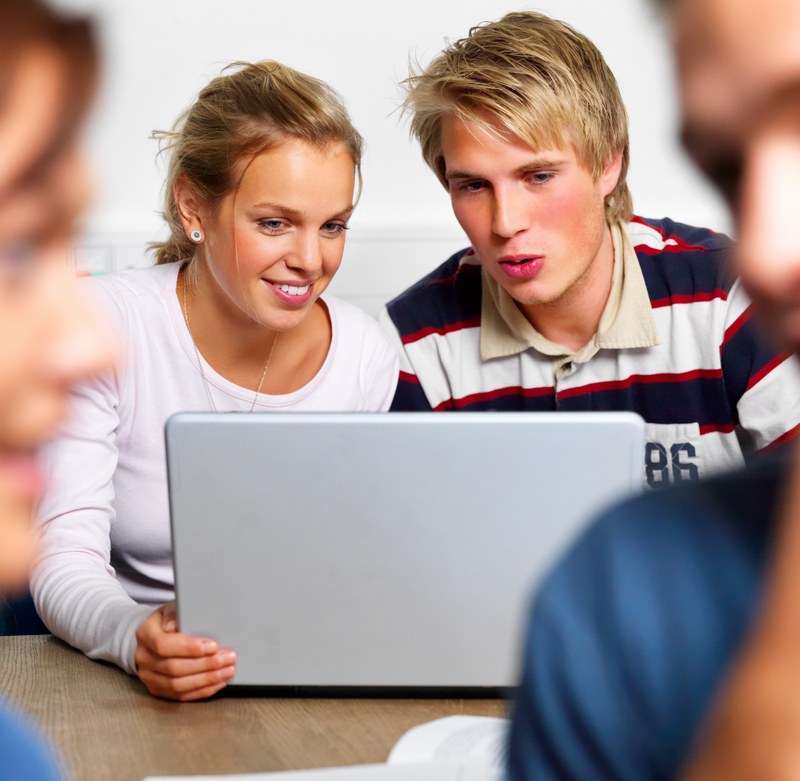 Продвинутое образование. Подросток за компьютером. Студенты смеются. Студент с ноутбуком. Молодежь и компьютер.