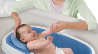 Картинка по теме - как держать новорожденных во время купания