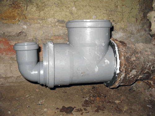 Соединение пластиковой и чугунной канализационных труб при помощи резинового уплотнителя